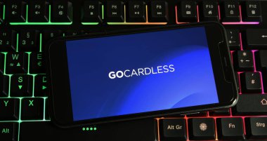 Viersen, Almanya - 9 Ocak. 2024: PC klavyesinde Gocardless logosu olan akıllı telefonun kapatılması