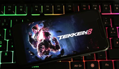 Viersen, Almanya - 9 Ocak. 2024: PC klavyesinde Tekken 8 oyunu logosu ile akıllı telefonun kapatılması