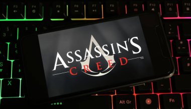 Viersen, Almanya - 9 Ocak. 2024: Suikastçilerin Creed oyununun logosu ile birlikte klavyedeki akıllı telefonun kapatılması