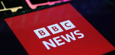 Viersen, Almanya - 1 Mart. 2024: Bilgisayar klavyesinde BBC 'nin flaş haberlerinin yer aldığı akıllı telefonun kapatılması