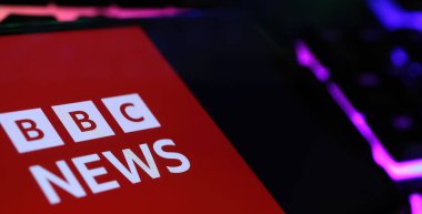 Viersen, Almanya - 1 Mart. 2024: Bilgisayar klavyesinde BBC 'nin flaş haberlerinin yer aldığı akıllı telefonun kapatılması