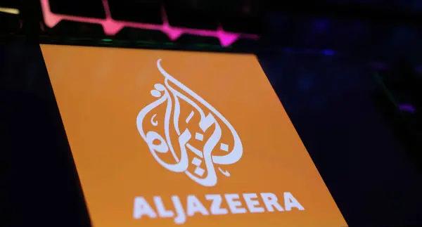 stock image Viersen, Germany - April 1. 2024: Smartphone screen on computer keyboard with logo lettering of Al Jazeera arabic television