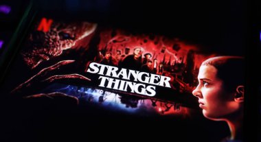 Viersen, Almanya - 3 Nisan. 2024: Netflix serisi Yabancı şeyler bilgisayar klavyesindeki akıllı telefon ekranında poster kapağı