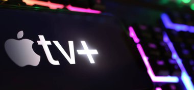 Viersen, Almanya - 1 Mayıs. 2024: Apple TV 'nin logosuna sahip akıllı telefon artı bilgisayar klavyesinde