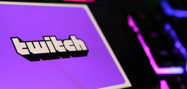 Viersen, Almanya - 1 Mayıs. 2024: Bilgisayar klavyesinde Twitch 'in canlı yayın servisinin logosuna sahip akıllı telefon