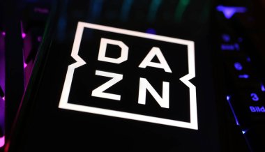 Viersen, Almanya - 1 Mayıs. 2024: Bilgisayar klavyesinde DAZN spor yayın servisinin logo harfleriyle akıllı telefonun kapatılması