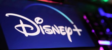 Viersen, Almanya - 1 Mayıs. 2024: Bilgisayar klavyesindeki Disney Plus yayın servis kanalının logo harfleriyle akıllı telefonun kapatılması