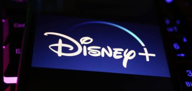Viersen, Almanya - 1 Mayıs. 2024: Bilgisayar klavyesindeki Disney Plus yayın servis kanalının logo harfleriyle akıllı telefonun kapatılması