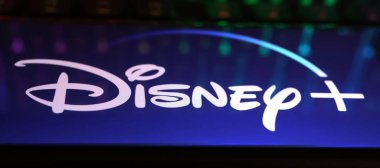 Viersen, Almanya - 1 Mayıs. 2024: Bilgisayar klavyesindeki Disney Plus yayın servis kanalının logo harfleriyle akıllı telefonun kapatılması
