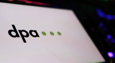 Viersen, Almanya - 9 Mayıs. 2024: Bilgisayar klavyesinde DPA Alman basın ajansının logo harfleriyle akıllı telefonun kapatılması