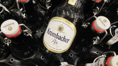 Viersen, Almanya - 9 Haziran. 2024: Alman dükkanında bira sandığında bir şişe Krombacher Pils