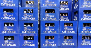 Viersen, Almanya - 9 Aralık. 2024: Alman dükkanında bir yığın mavi Alman Oettinger bira kasası (merkeze odaklan)