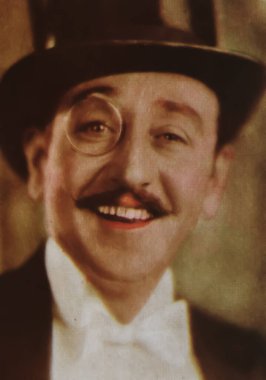 Viersen, Almanya - 1 Temmuz. 2024: Amerikan aktör Adolphe Menjou 'nun 1940' lardan kalma tek gözlüklü fotoğrafı (yüze odaklan)
