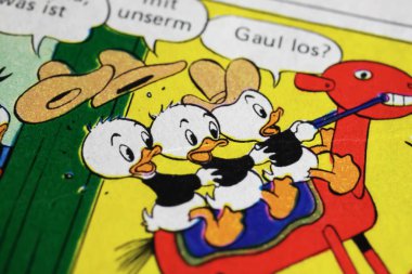 Viersen, Germany - May 9. 2024: Old photo of german Donald Duck comic with Huey, Dewey and Louie from 1988 (focus on center) clipart