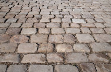 Tarihi kaldırım taşlarının arka planı ve dokusu. Taşlar farklı boyutlarda. Asfalt ön taraftan çekiliyor.