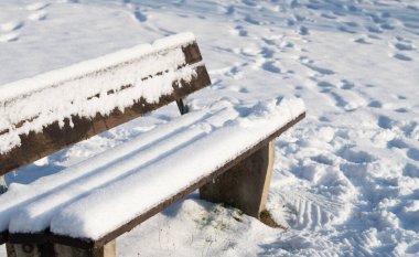 Kışın karın ortasında beyaz bir ahşap bank vardır. Yedek kulübesi de karla kaplı. Metin için boşluk var.