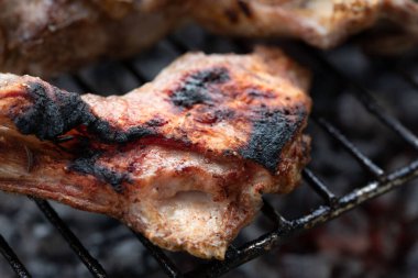 Izgarada ızgara için bekleyen et parçaları. Kömürler etin altında kırmızı parlıyor..