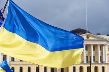 Helsinki, Finlandiya - 26 Mart 2022: Helsinki 'deki Senato Meydanı' nda Rusya 'ya karşı düzenlenen mitingde arka planda Fin Hükümet Sarayı ile birlikte Ukrayna bayrakları.