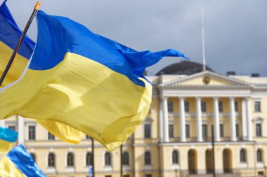 Helsinki, Finlandiya - 26 Mart 2022: Helsinki 'deki Senato Meydanı' nda Rusya 'ya karşı düzenlenen mitingde arka planda Fin Hükümet Sarayı ile birlikte Ukrayna bayrakları.