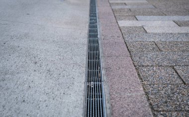 Japonya 'da, Tokyo kaldırımında paslanmaz çelik rendelenmiş su rögarı.