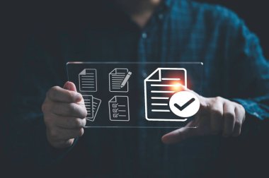 Sanal belge ve çevrimiçi kağıtsız proje belgesi ve kalite güvencesi kavramı için doğru işaret işareti içeren sanal tablet tutan bir işadamı.