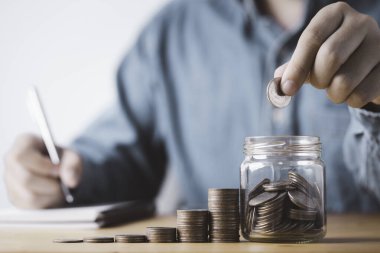 Yatırım için para biriktiren işadamı, para biriktiren ve kar elde etmek için para biriktiren kavanoz bankasına para yatırıyor.. 