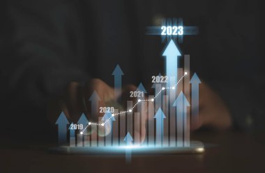 Sanal artan teknik grafikle el ele tutuşan akıllı telefon ve tüccar analizi için yükselen ok borsa konsepti.