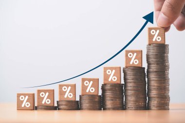 Increasing coin stacking with up arrow and percentage sign for increase financial interest rate and business investment growth from dividend concept.