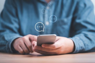 İş adamı, iş arkadaşına mesaj göndermek için akıllı telefon daktilo kullanıyor. Sohbet ve sosyal ağ teknolojisi konseptiyle iletişim..