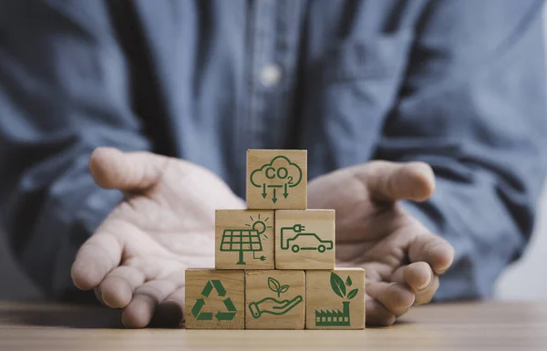 Man hand give stacking CO2 reducing ,Recycle ,Green factory icon for decrease CO2 , carbon footprint and carbon credit to limit global warming from climate change, Bio Circular Green Economy concept.