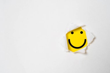 Smile face inside yellow background and white punch paper with copy space for positive mindset and client excellent evaluation concept , Customer experience and quality feedback concept.
