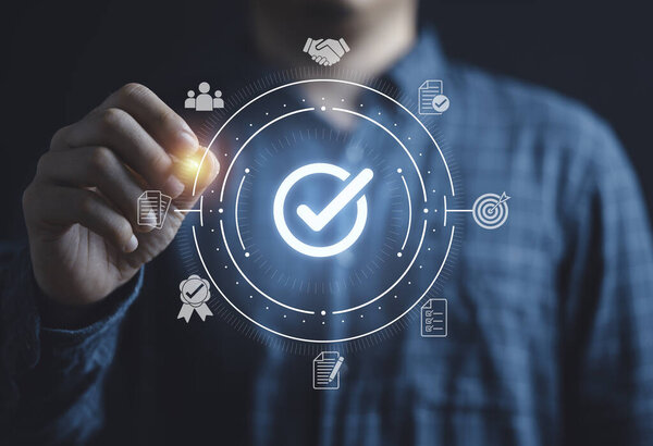 Бизнесмен пишет светящийся правильный знак или галочку для обеспечения контроля качества ISO стандарта и концепции утверждения проекта.