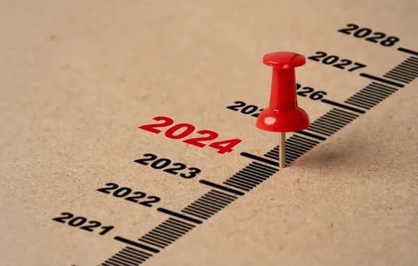 Hazırlık için 2024 yılla birlikte kırmızı raptiye. Mutlu Noeller ve mutlu yıllar konsepti..