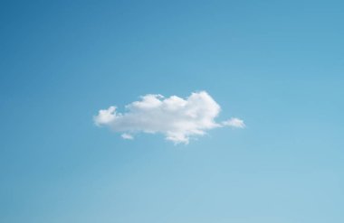 Yaz mevsimi değişim konseptinde mavi gökyüzünde beyaz buluttan yapayalnız.