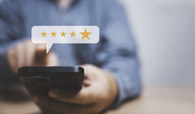 İş adamı, müşteri kullanımı hizmetleri, ISO ve kalite standart sertifikası konseptinden sonra değerlendirmek için akıllı telefon kullanarak beş yıldız verdi..