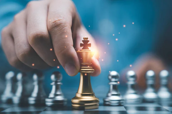 Podnikatel Držící Zlaté Královské Šachy Před Stříbrnými Šachy Pěšáka Šachovnici — Stock fotografie