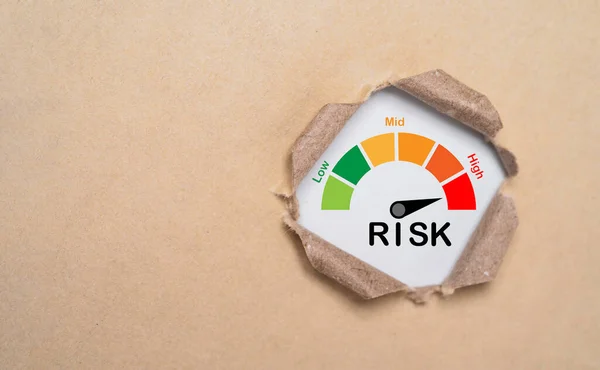 Risk level indicator rating inside punch brown paper from low to high on for business risk management analysis and assessment concept.