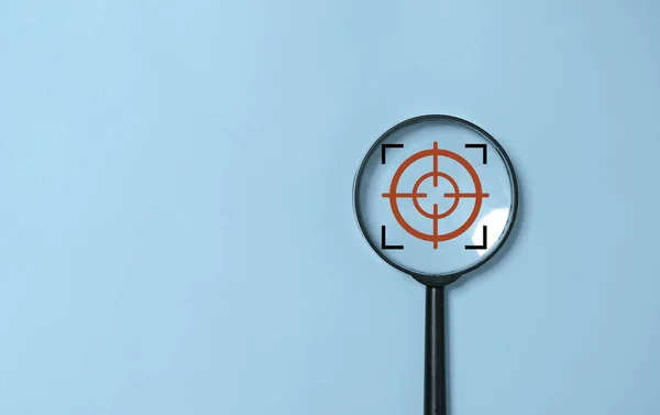 Focus icon inside of magnifier glass for concentrate business in  objective target on blue background and copy space.