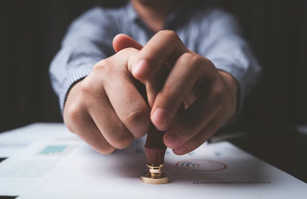 stock image Closeup of businessman hand stamping approve project and quality document on desk , Certificate and ISO concept.