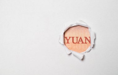 Çin banknotundan Yuan sözcüğü yumruklanmış kağıdın içinde, Yuan banknotu dünyanın en büyük döviz kurudur..