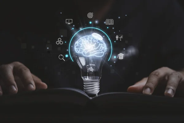 Virtual brain inside lightbulb on open book between two hand for creative thinking idea to solve problem from learning knowledge and innovation concept.