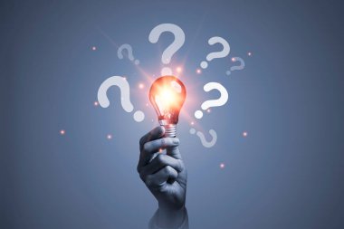 Yaratıcı yenilik fikri ve problem çözme konsepti için soru işaretiyle el ele tutuşan parlak ampul.