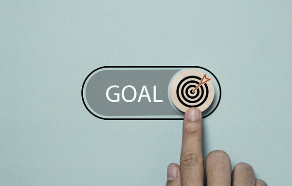 Hand touching to toggle with button with dartboard and arrow to open status for start business objective target and goal concept.