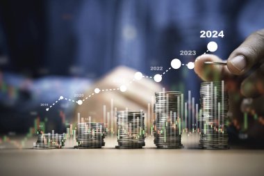 İşadamı, 2024 konseptinde artan borsa grafiği, iş yatırımı karı ve mevduat kar payı artışı içeren madeni paraları istifliyor..