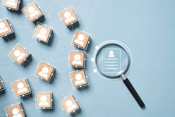 Büyüteç cam bağlantısının içinde insan geliştirme işe alma kavramının araştırılması için mavi arkaplandaki insan simgesiyle simgeye devam et.