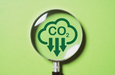 Kyoto Protokolü 2050 'deki iklim değişikliğinden küresel ısınmayı sınırlamak için CO2' nin yeşil arka planda azaltılması, karbon ayak izi ve karbon kredisi içeren büyüteç..