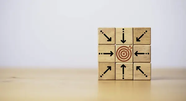 Center dartboard with arrow which print screen on wooden cube for focus on Business achievement goal and objective target concept.