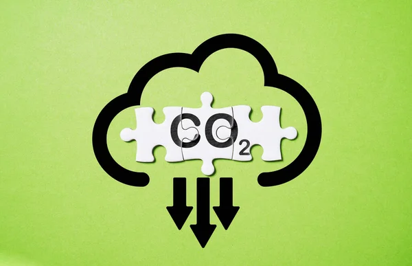 CO2 reducing icon on white jigsaw  for decrease CO2 , carbon footprint and carbon credit to limit global warming from climate change, Bio Circular Green Economy concept.