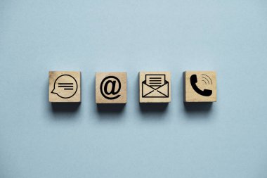 Kişi simgeleri arasında, müşteri yardım hattı servis konsepti için mesaj adresi e-posta ve ahşap blok küp üzerindeki telefon ve mavi arkaplan içerir.