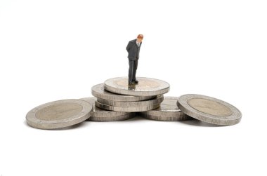 Analiz için birikmiş madeni paralar üzerinde duran ve düşünen işadamlarının minyatür figürü ve iş büyüme kavramına yatırım yapmayı düşünün.